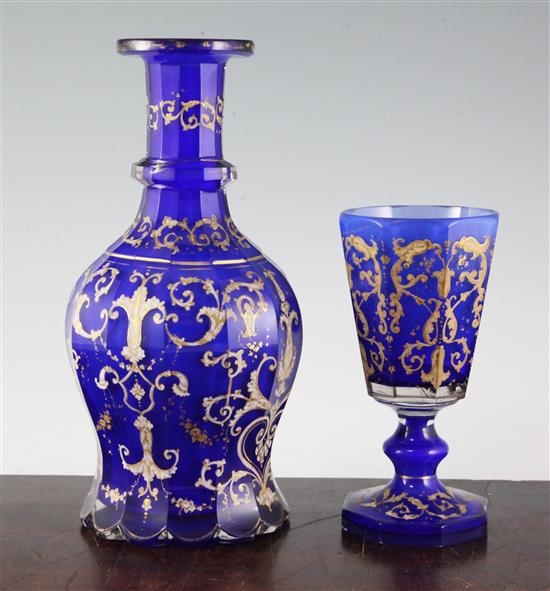 A Bohemian gilt decorated and white enamelled blue glass decanter and matching goblet, late 19th century, 26.5cm and 17.3cm, manufactur
